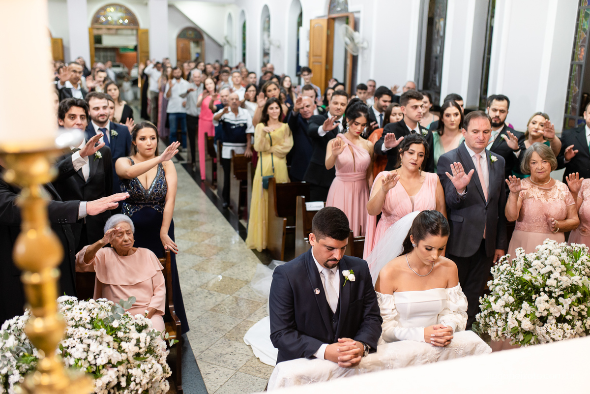Noivos orando de joelho no casamento em caratinga