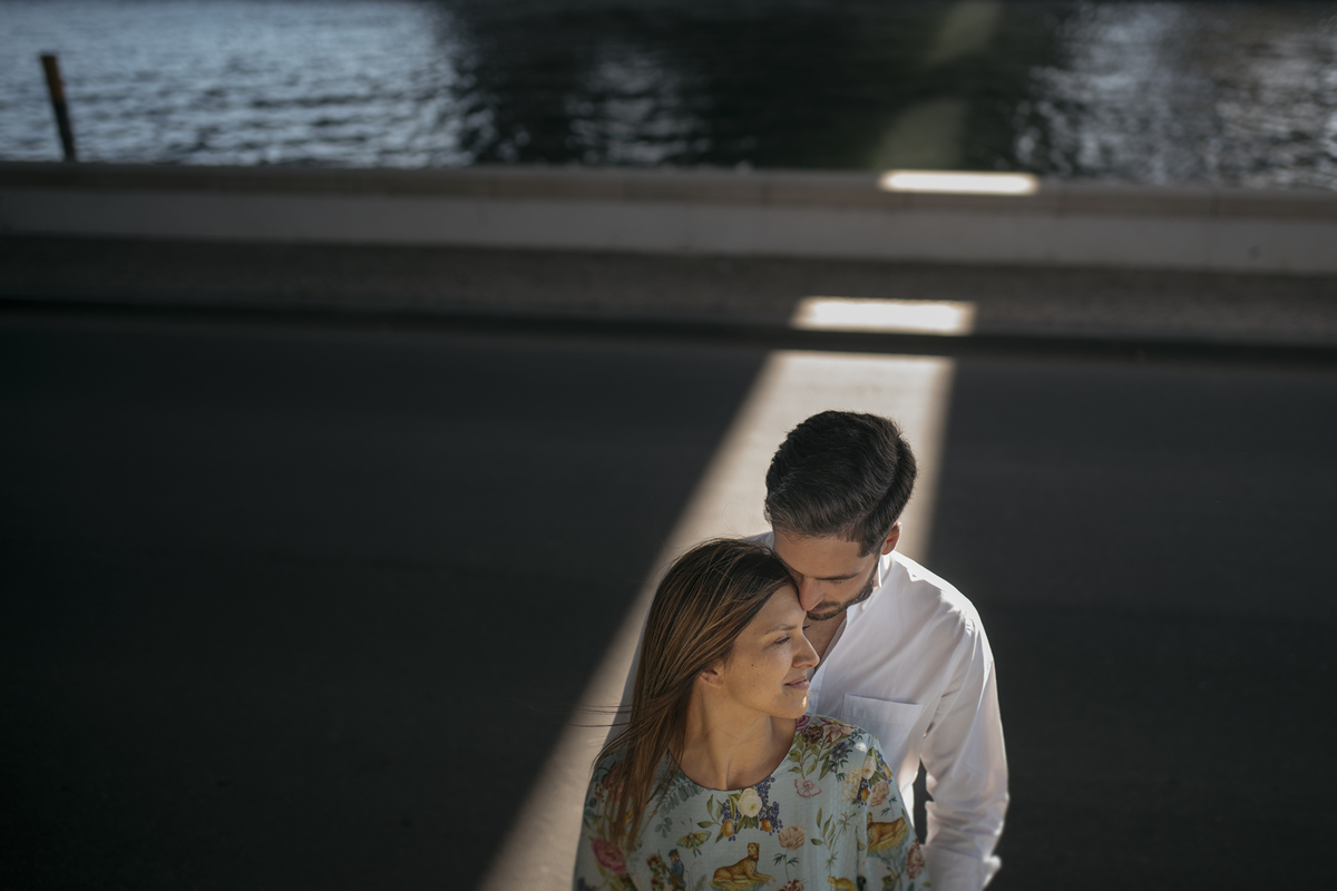 noivos em momento intimo de baixo de uma ponte sobre um raio de luz