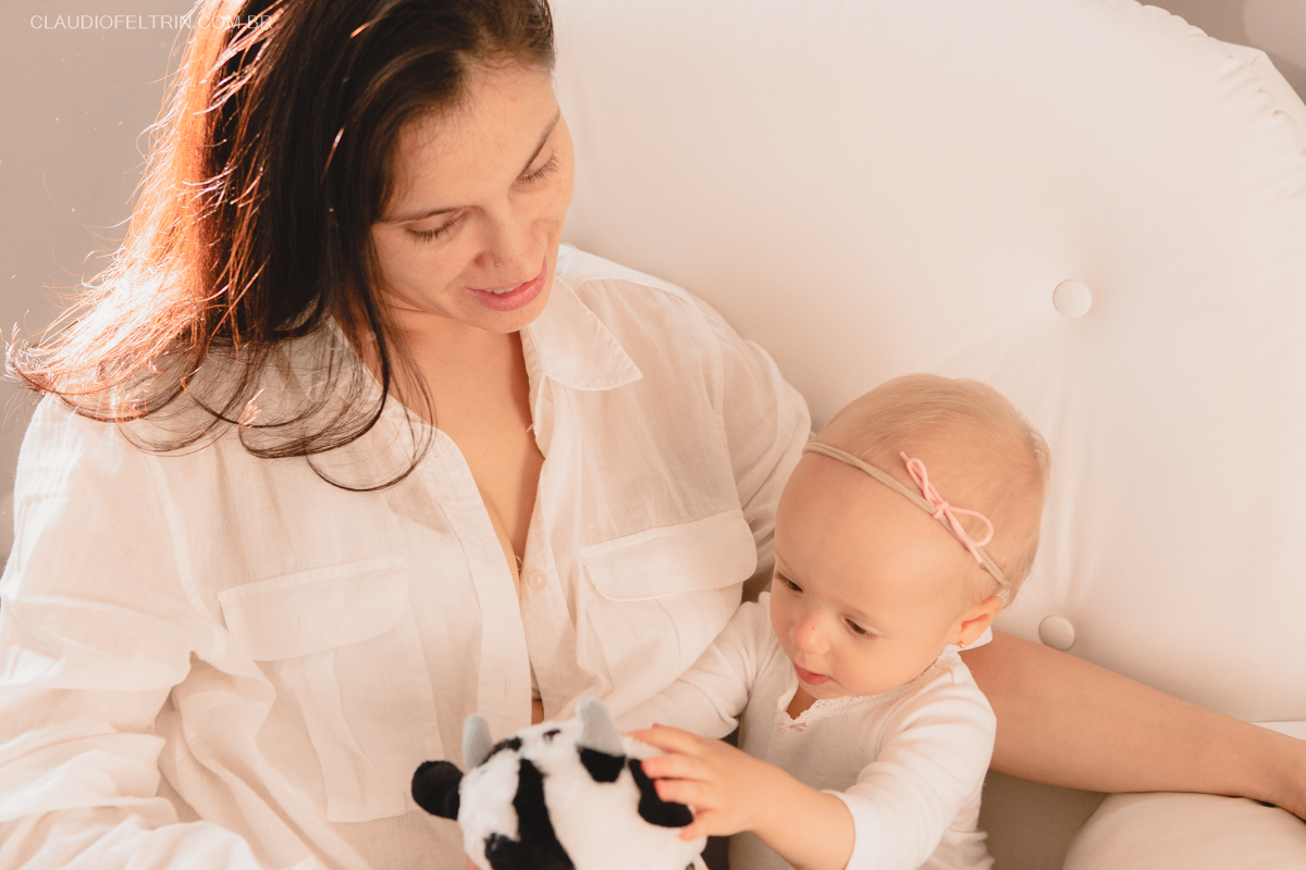 filha brincando com o bichinho de pelúcia no ensaio fotografico