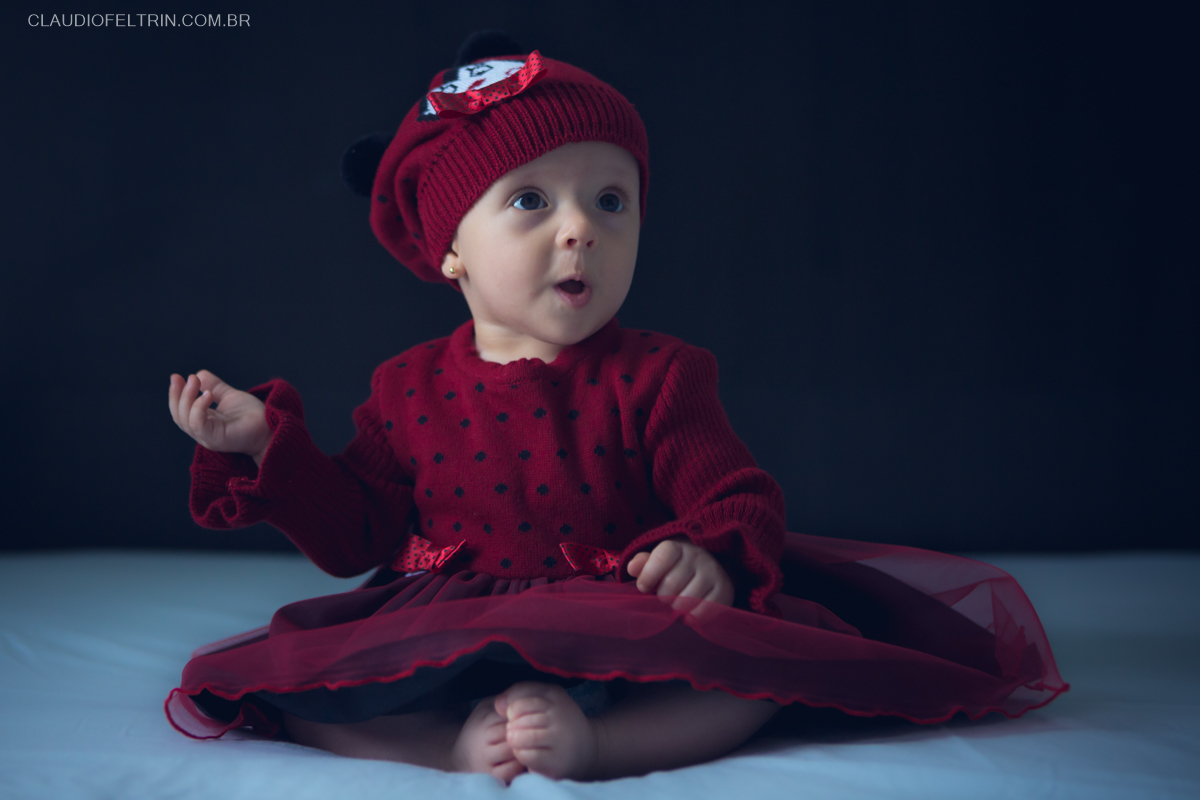 lindo bebê fazendo poses para ser fotografada em um lindo ensaio de criança, com a mãozinha para o lado