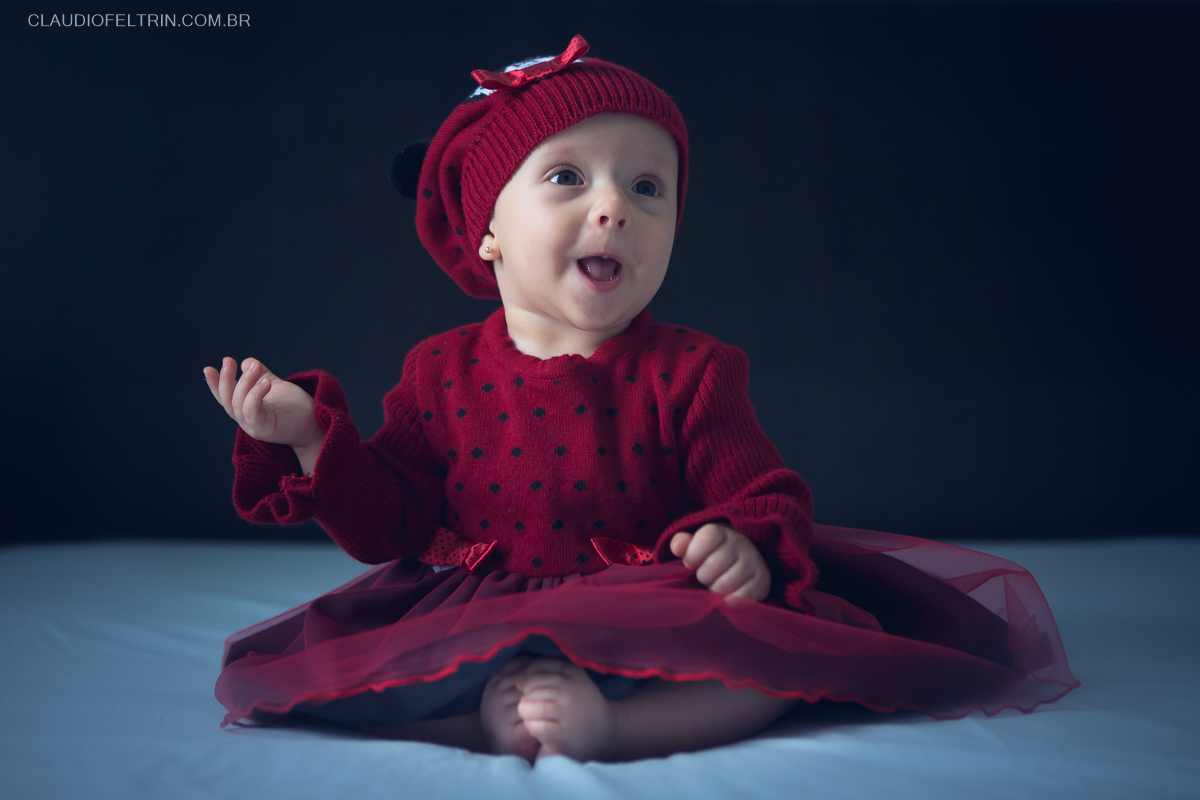 neném rindo e fazendo careta para o fotografo fazer o ensaio de bebê