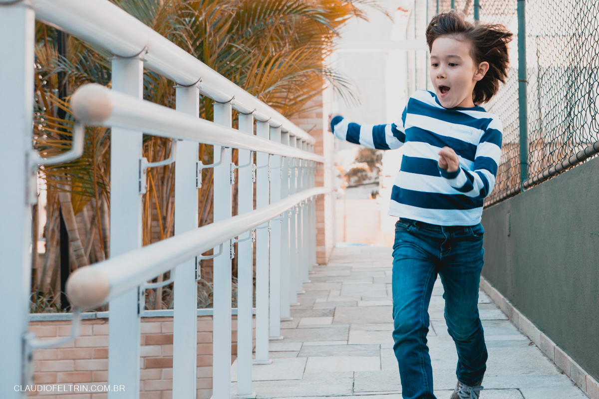 menino descendo o corredor correndo e os cabelos balançando com o vento