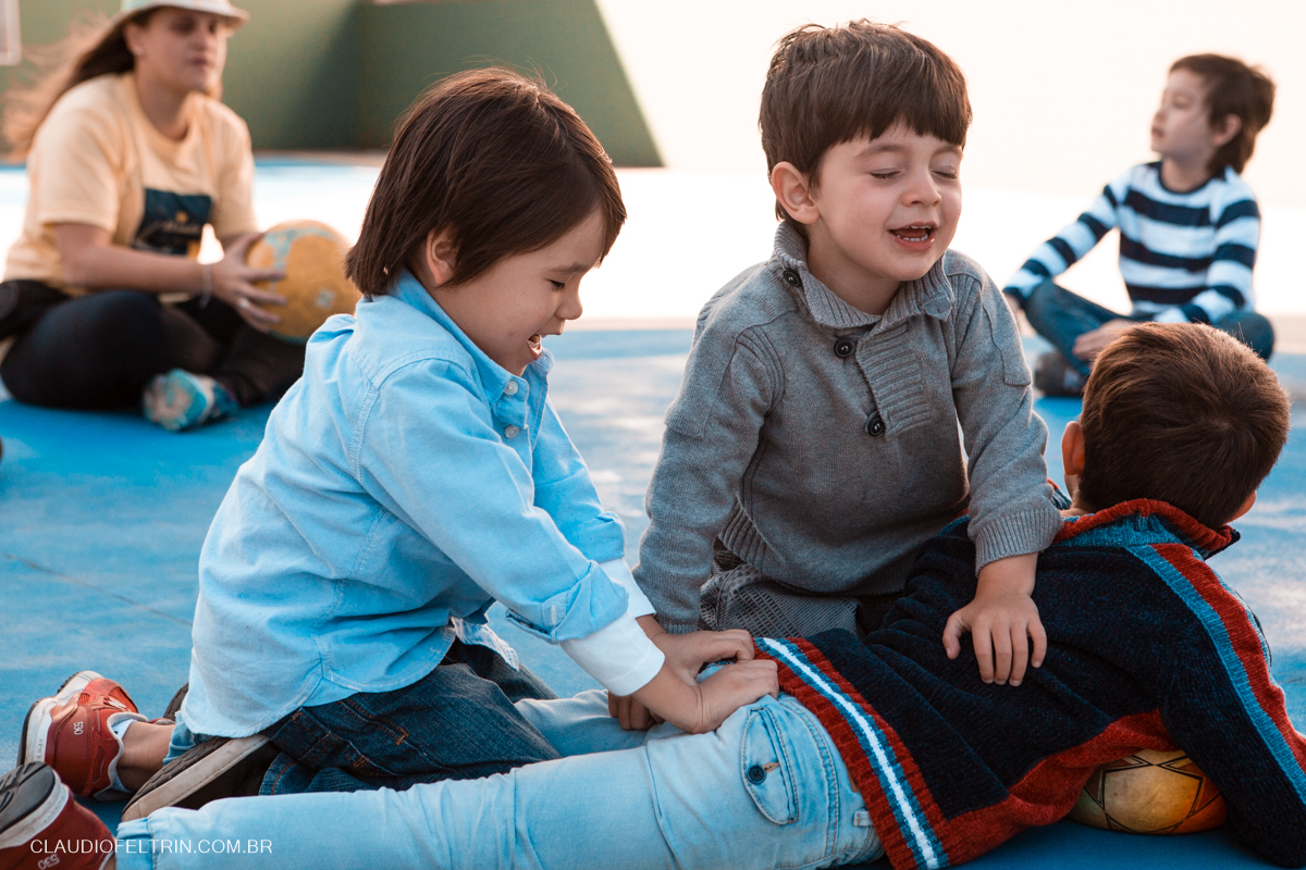 primos pulando um em cima do outro na quadra de futebol