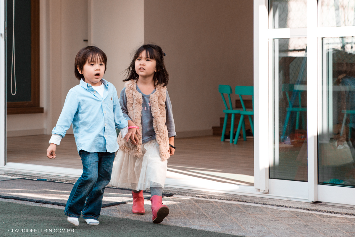 Dois primos andando de mãos dadas pela festa