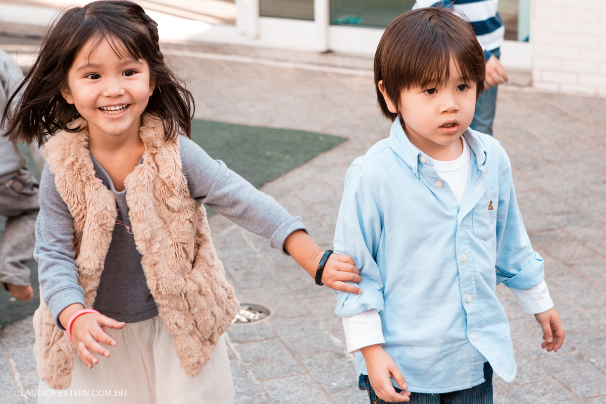 primo e prima olhando para ver o que vai acontecer e a menina começa a sorrir