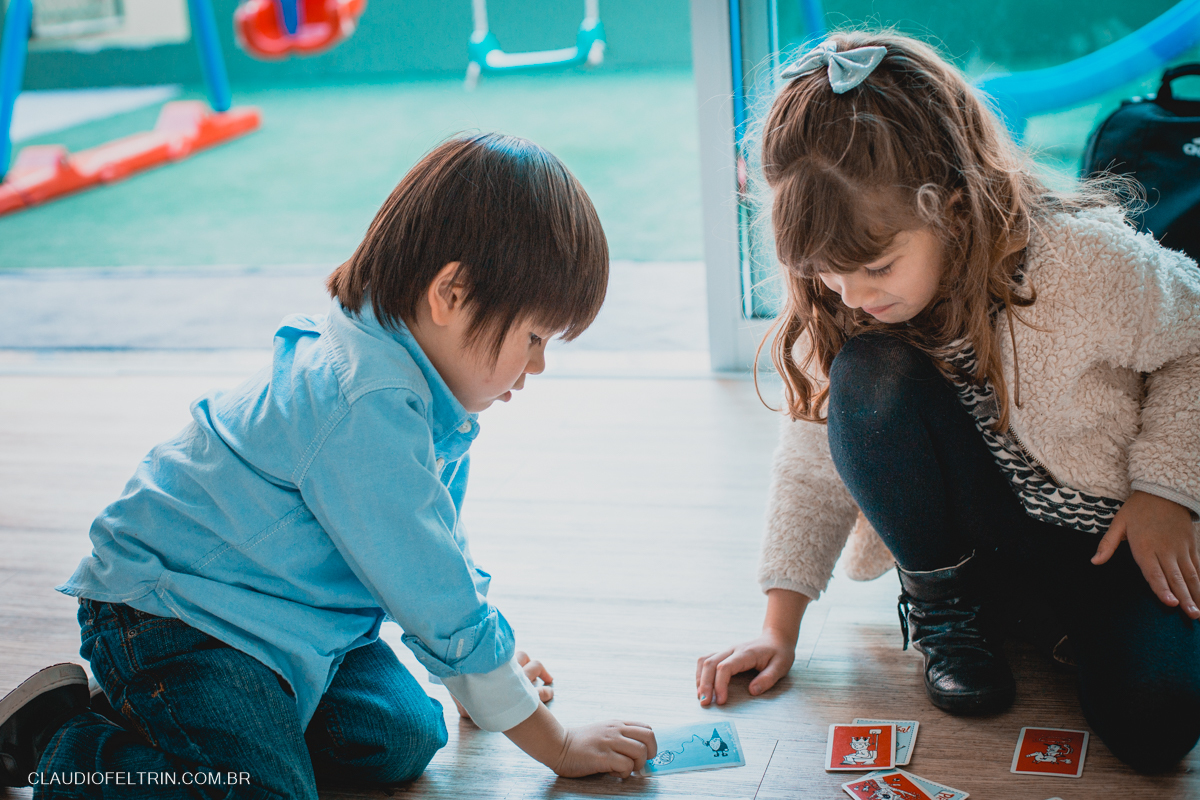 aniversariante jogando baralho com a priminha no chão