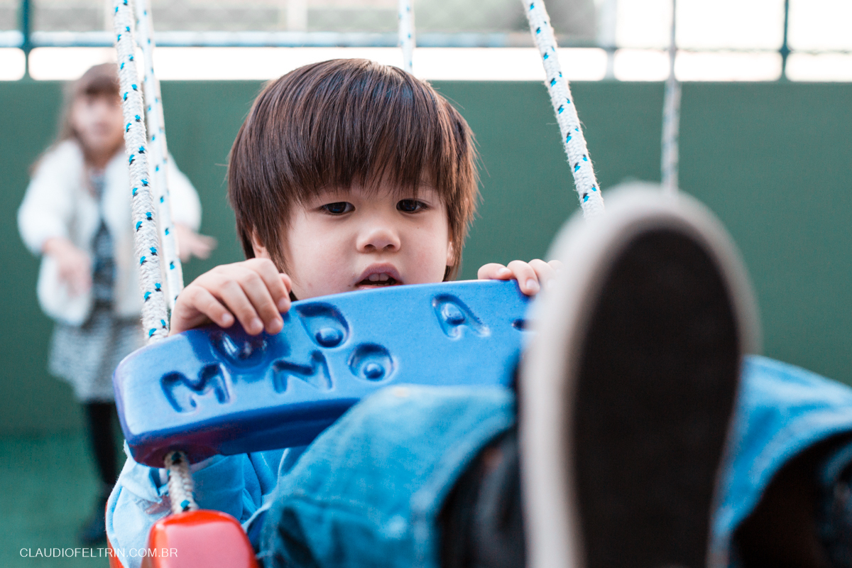 aniversariante no balanço que acaba de ser empurrado pela prima