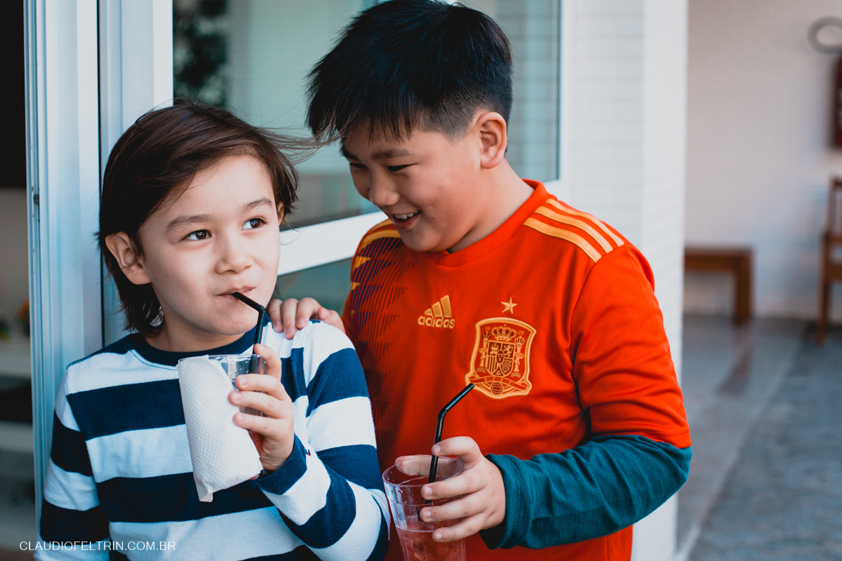 dois primos conversando e tomando um suco com canudinho