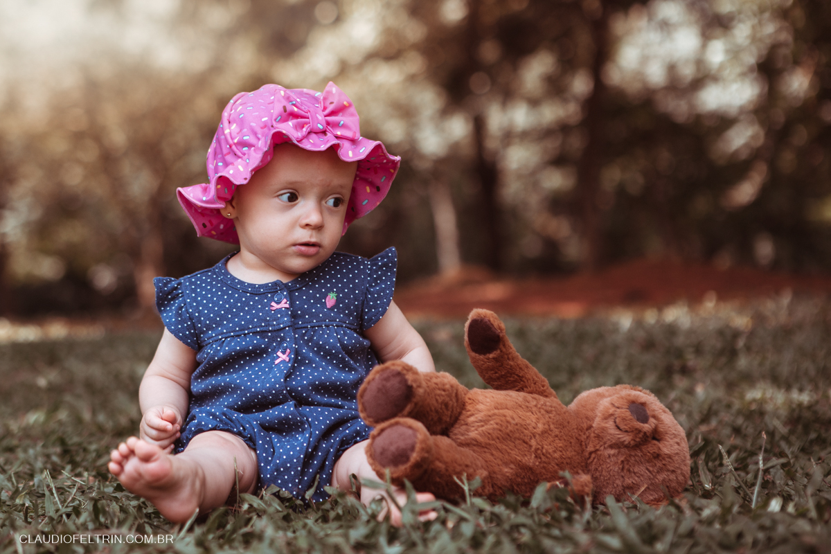 ensaio de criança em dia ensolarado com ursinho de pelúcia