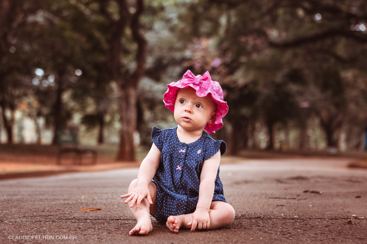 sentada no chão a criança olha para cima em ensaio fotográfico infantil 