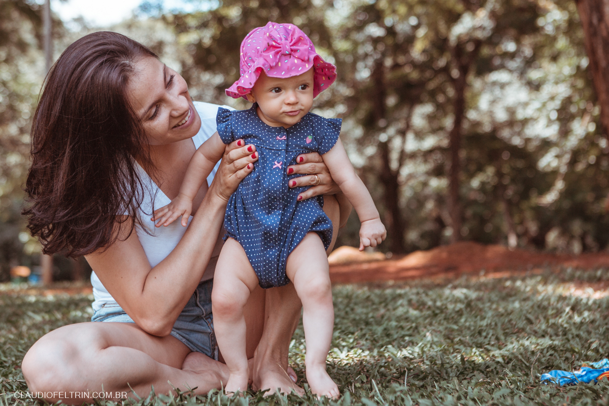 a criança levanta com alegria no parque em sessão fotografica