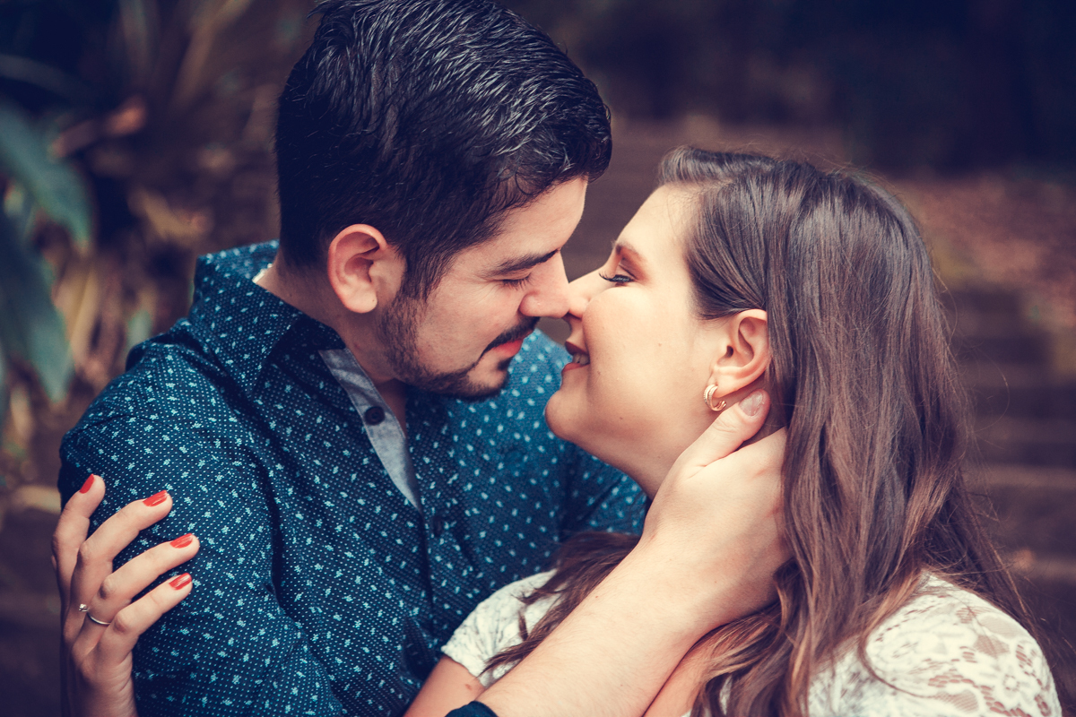 o noivo toma a noiva pelos braços e a beija em ensaio fotográfico