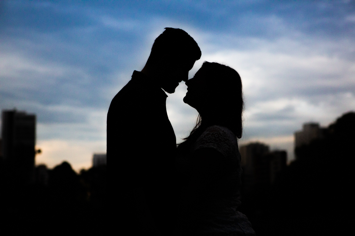 a silhueta dos noivos se olhando em lindo final de tarde em ensaio fotográfico no parque da aclimação 