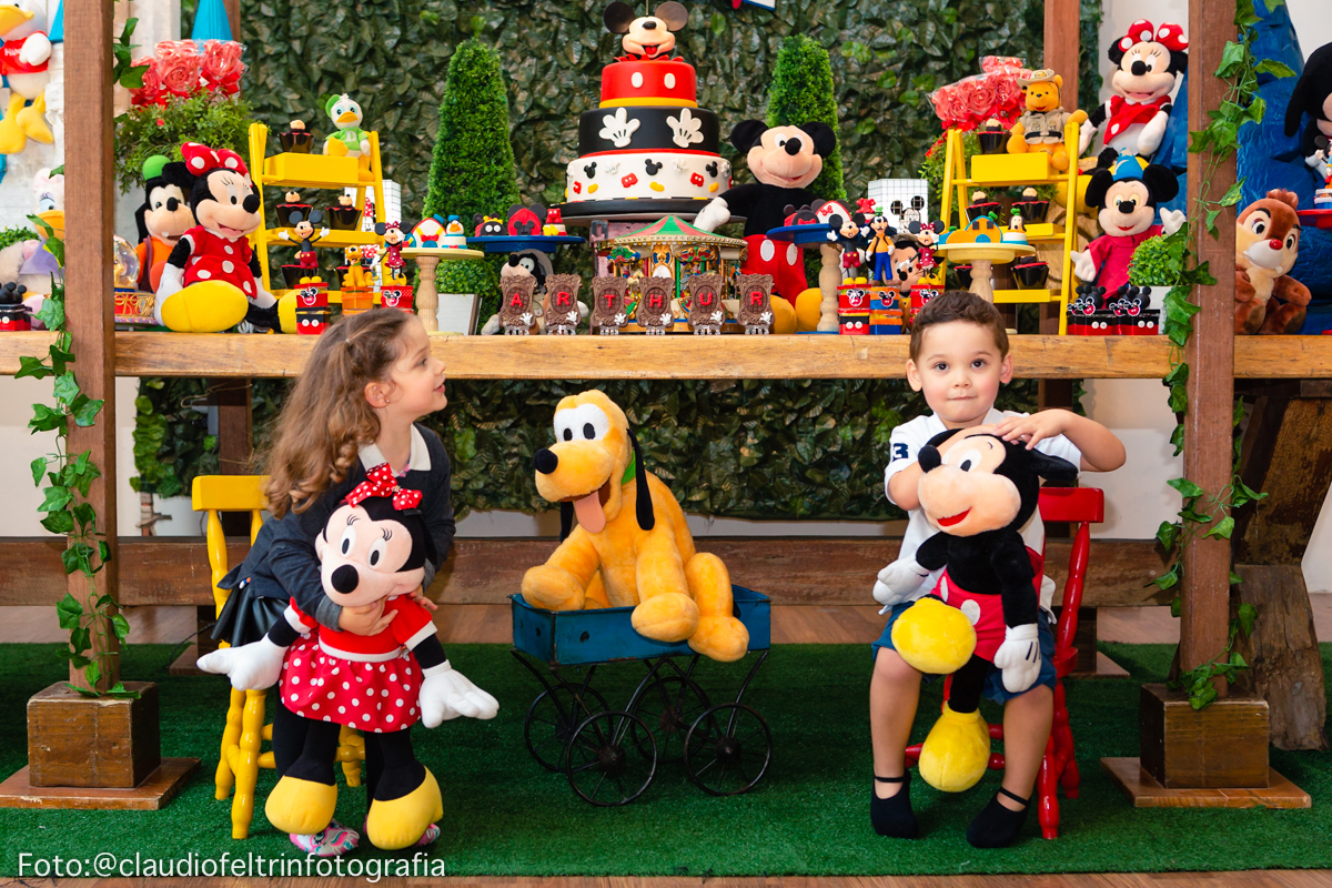 aniversariante posando em frente a mesa de bolo