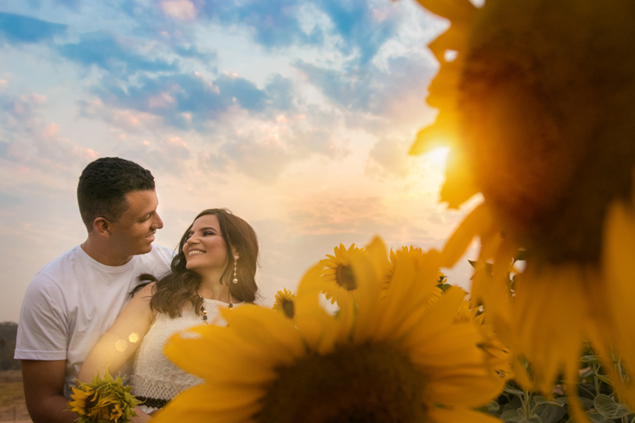 Noivos sorrindo no meio de girassóis em Florestal