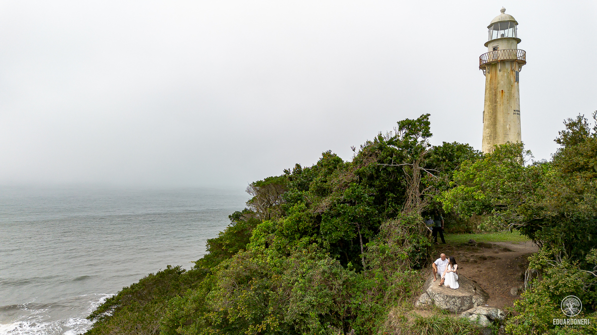 Jessica e Samuel no pre-wedding na Ilha do Mel, Paraná. Foto no Farol da Ilha com vista deslumbrante, capturando amor e emoção neste cenário icônico