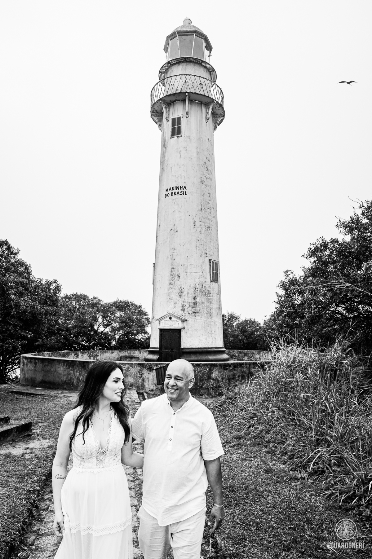 Jessica e Samuel no pre-wedding na Ilha do Mel, Paraná. Foto no Farol da Ilha com vista deslumbrante, capturando amor e emoção neste cenário icônico