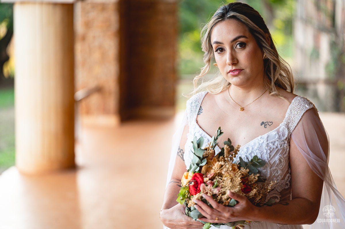 Noiva caminhando entre paredes de pedra no Hotel Yara, em ensaio fotográfico criativo