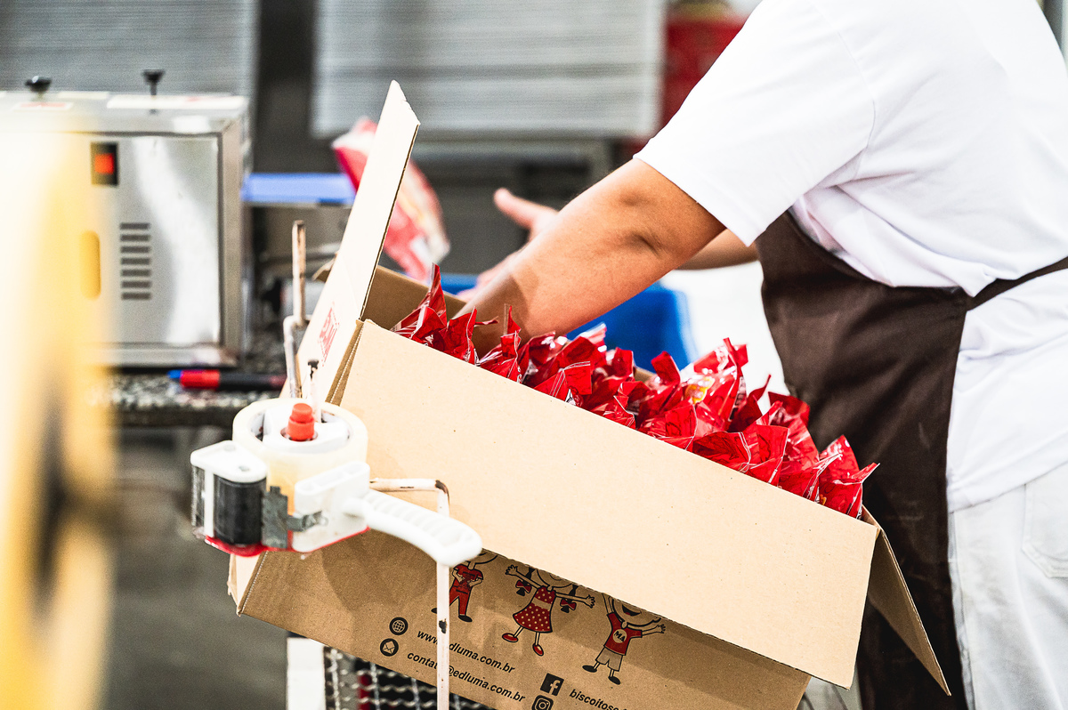 Equipe dos Biscoitos Edluma atuando na fabricação de biscoitos com higiene, padronização e cuidado, reforçando o compromisso da empresa com qualidade e excelência na produção.