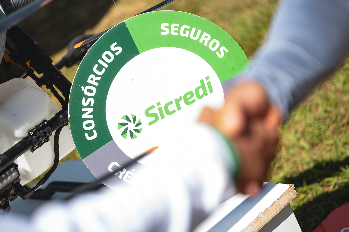 Associados e visitantes negociando propostas no stand da Sicredi durante a Coopershow 2026, fortalecendo o cooperativismo e o desenvolvimento do agro.