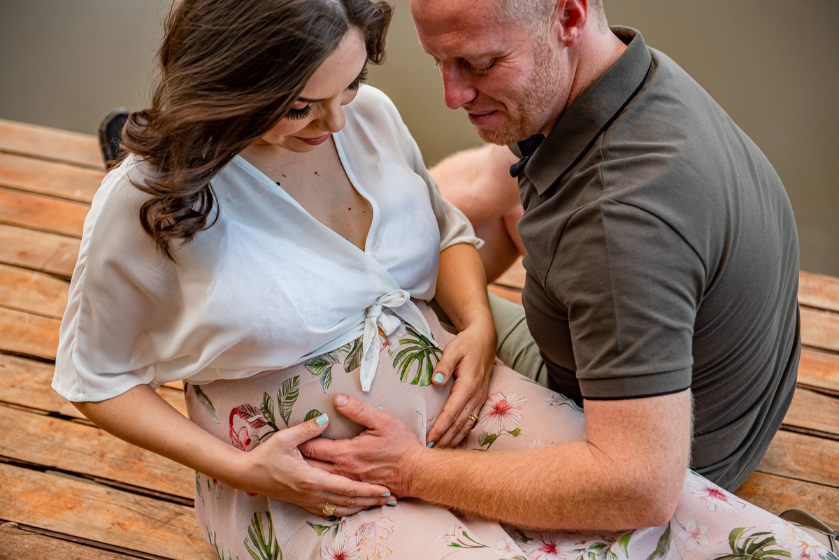 As mãos de Thais e Guilherme se encontram sobre a barriga, simbolizando o amor e a proteção dedicados à pequena Cecília antes mesmo de nascer.
