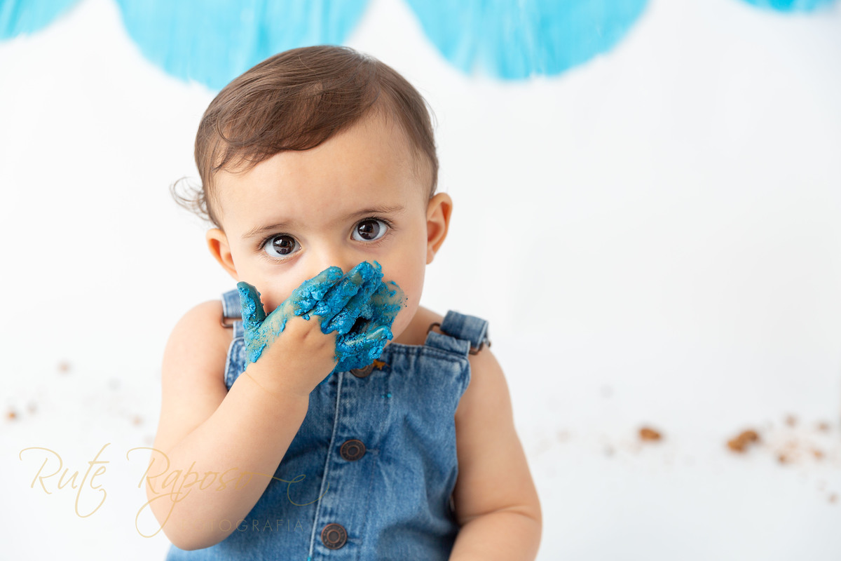 as suas mãos azuis são a prova de como adorou sentir a textura 
 do creme do bolo