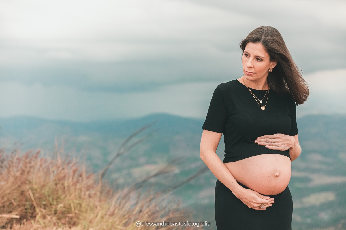 abracando a filha que vai chegar a gestante na sessao de fotos de gestante bh moeda no topo do mundo com roupa preta