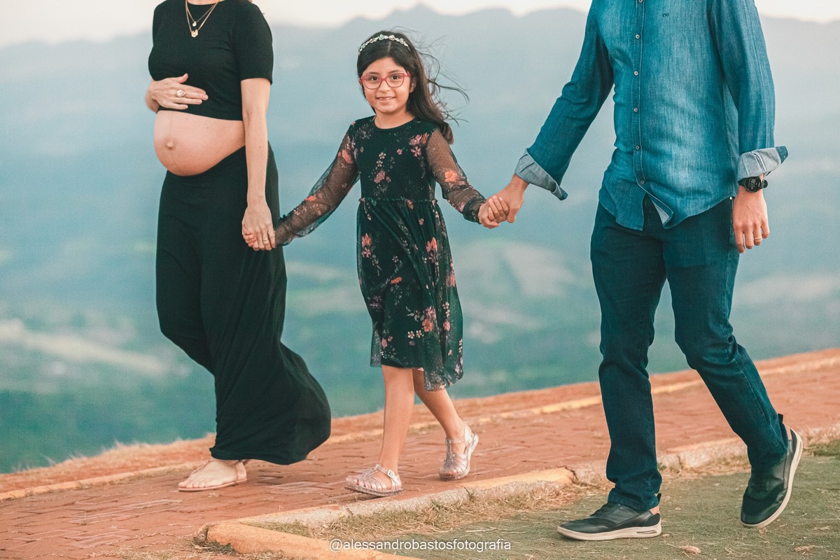 olhando para a camera a filha do casal no ensaio de fotos gestante bh topo do mundo dando as maos