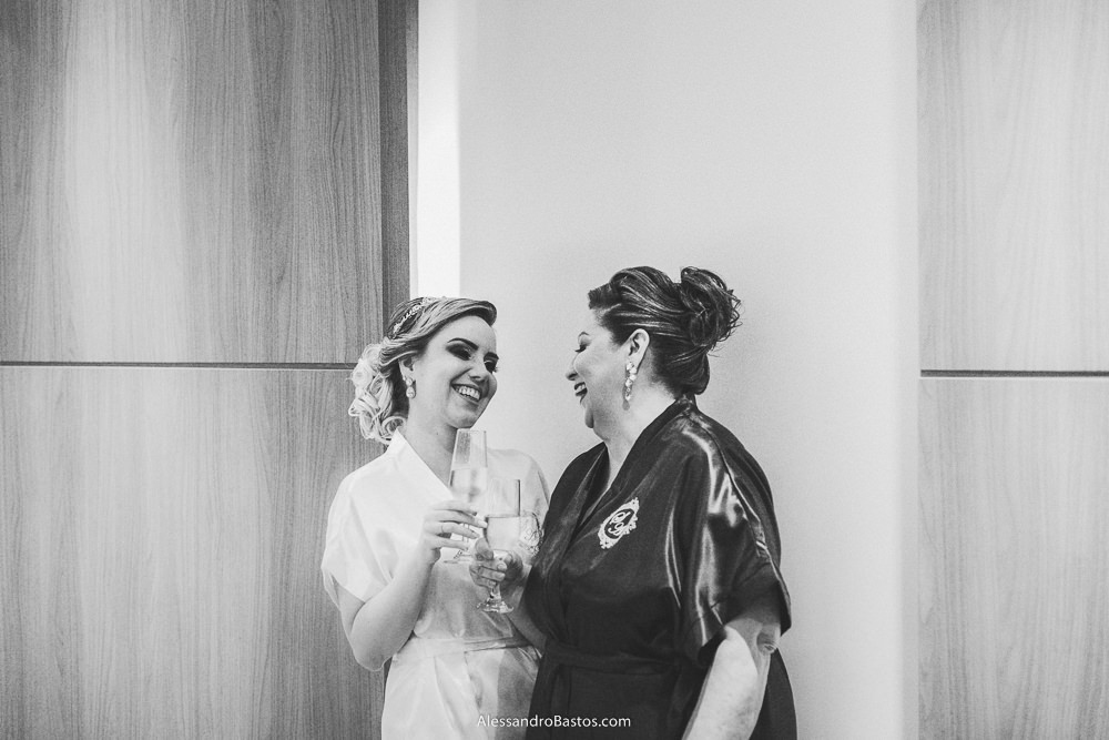 mãe da noiva do casamento em belo horizonte bh foto se diverte com a filha ao fazer um brinde antes de se vestirem