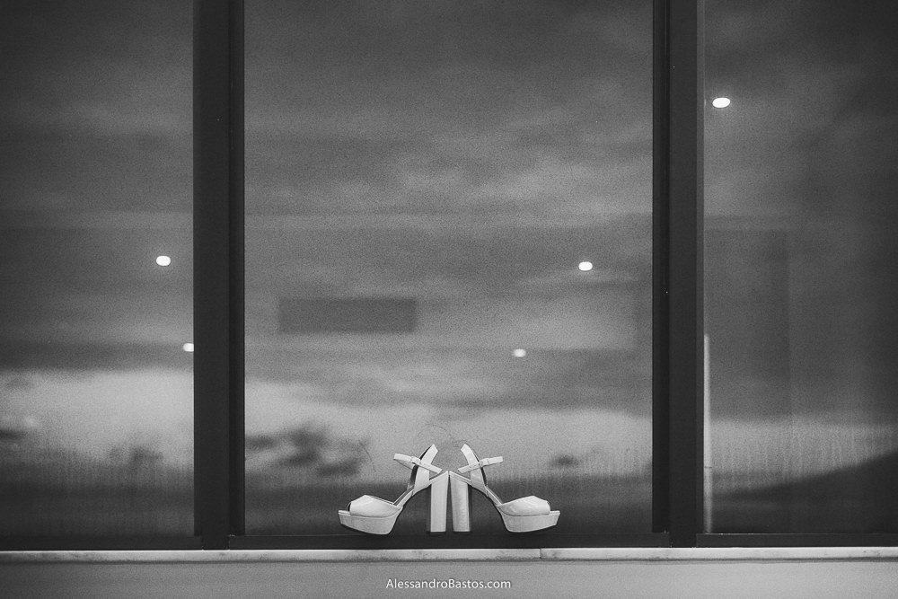 sapato da noiva do casamento em belo horizonte bh foto pendurado na janela do hotel com o sol se pondo