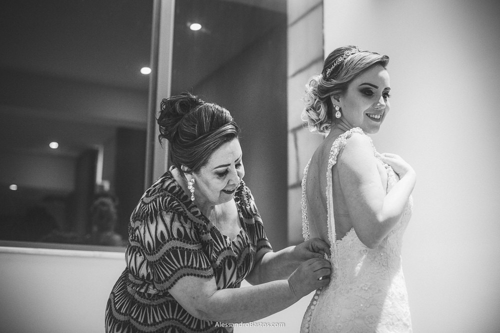 mãos da mãe da noiva do casamento em belo horizonte bh foto ajudam ela a colocar vestido antes de sair