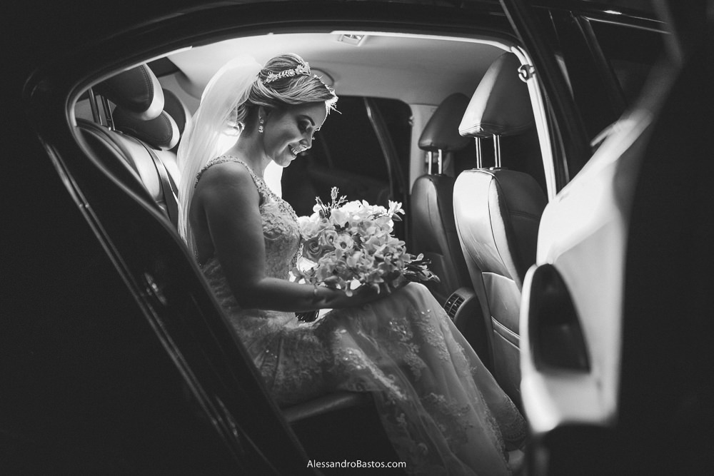 abrindo a porta do carro se vê a noiva do casamento em belo horizonte bh foto sentada no banco de trás