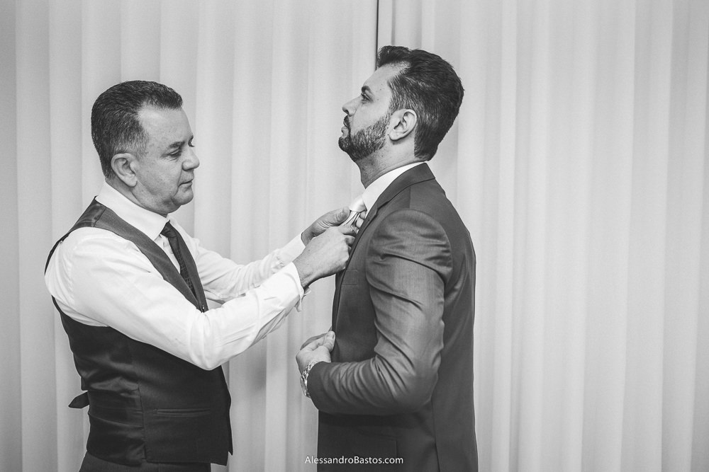 passando a mão pela gravata do noivo do casamento em belo horizonte bh foto está o pai dele para ajustar melhor no pescoço