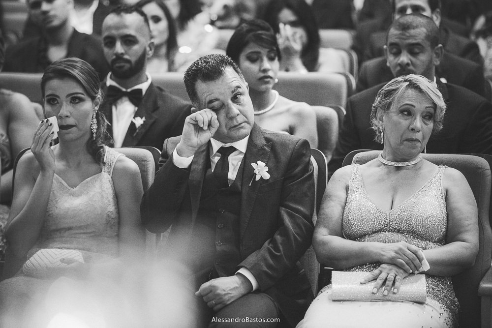 passando a mão pelos olhos mareados está o pai do noivo do casamento em belo horizonte bh foto ao lado da esposa