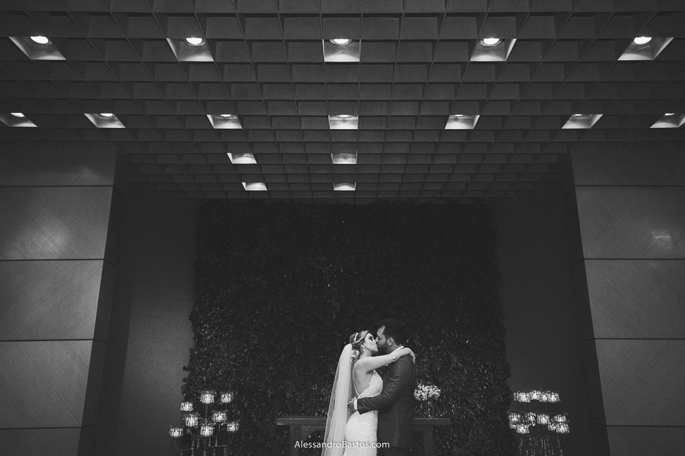 finalmente o beijo dos noivos do casamento em belo horizonte bh foto com as luzes da igreja na parte de cima