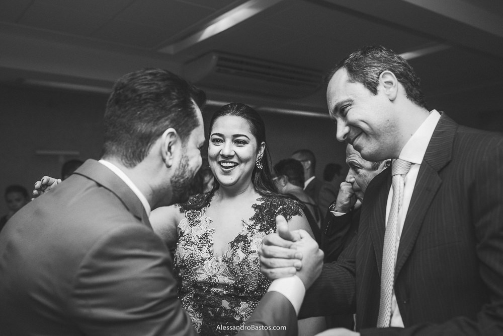 convidado aperta a mão do noivo do casamento em belo horizonte bh foto enquanto a esposa sorri