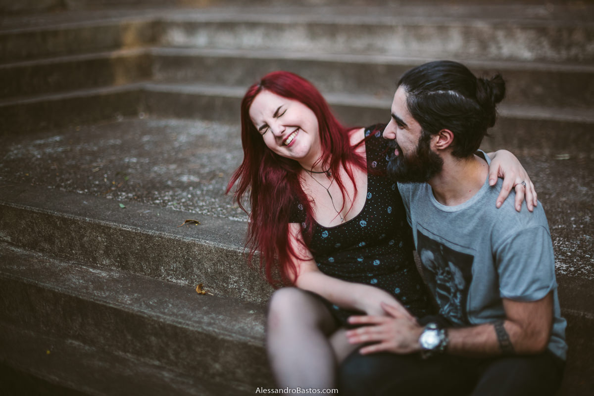 escadaria abriga os noivos em sessão de fotografia pré-wedding antes do casamento em bh e ela dá um sorriso lindo e espontâneo