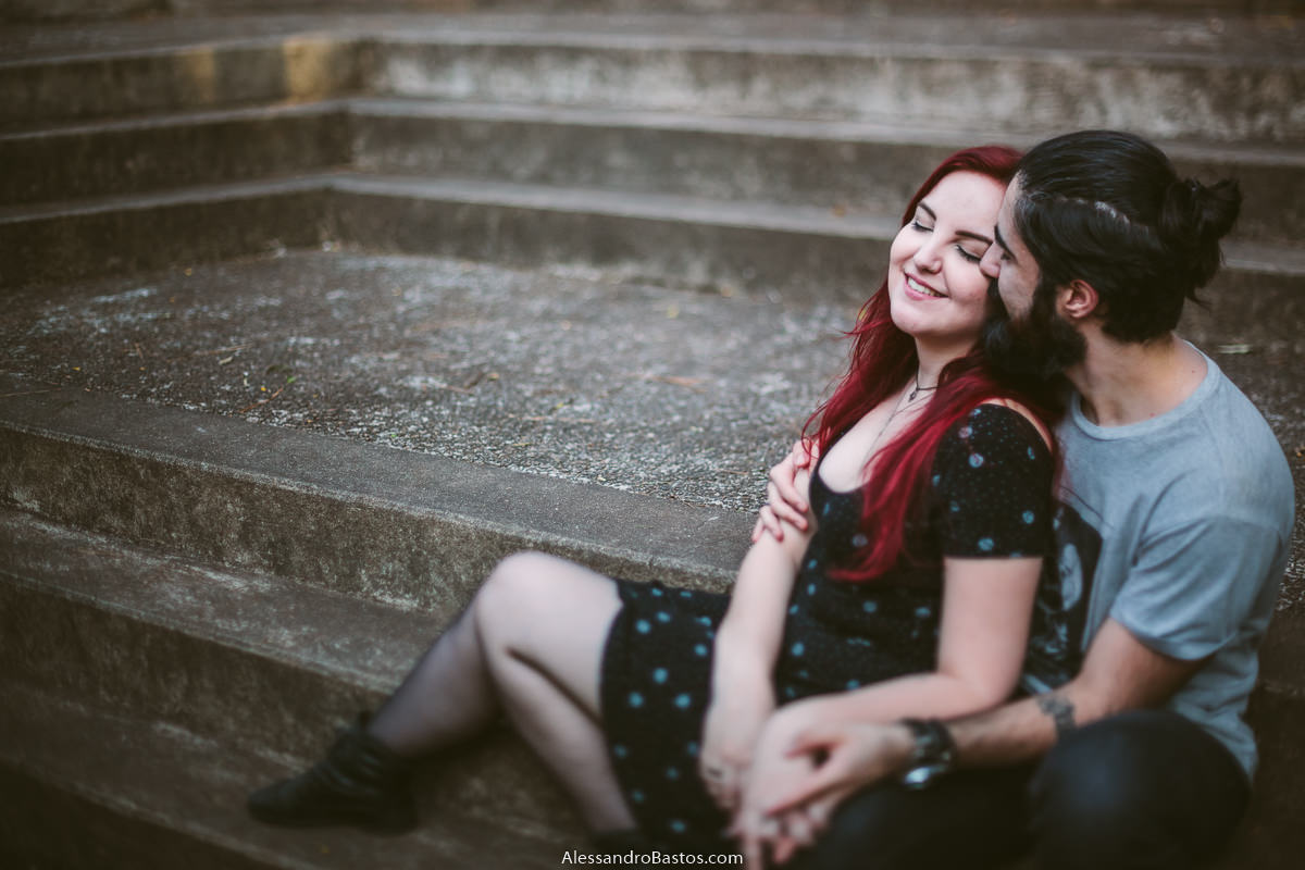 sentados na escadaria os noivos em sessão de fotografia pré-wedding antes do casamento em bh se abraçam forte