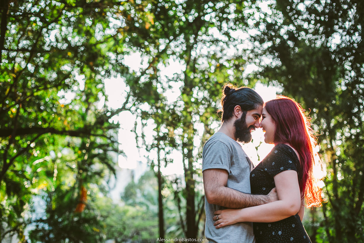 luz linda entrando pela mata com os noivos em sessão de fotografia pré-wedding antes do casamento em bh e um fundo verde