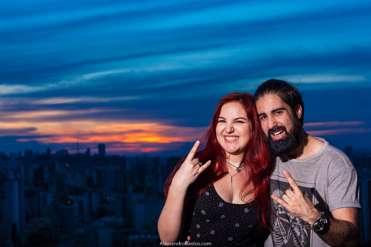 laranja intenso é visto na foto com os noivos em sessão de fotografia pré-wedding antes do casamento em bh enquando eles fazem sinal com as mãos