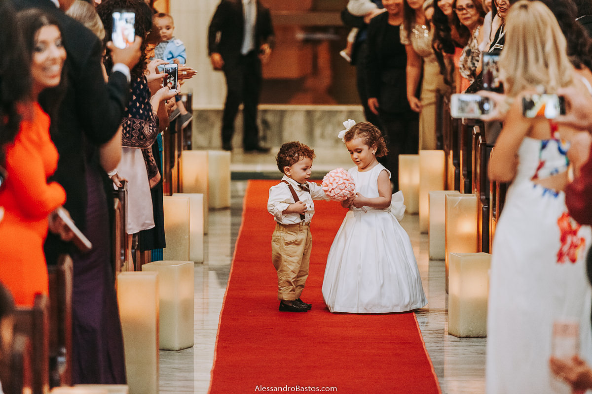 segundo casal de damas e pajens fotografo casamento bh pre-wedding pre-casamento pos-casamento fotografia belo horizonte entrando na igreja santo cura d'ars observam o buquê de bala