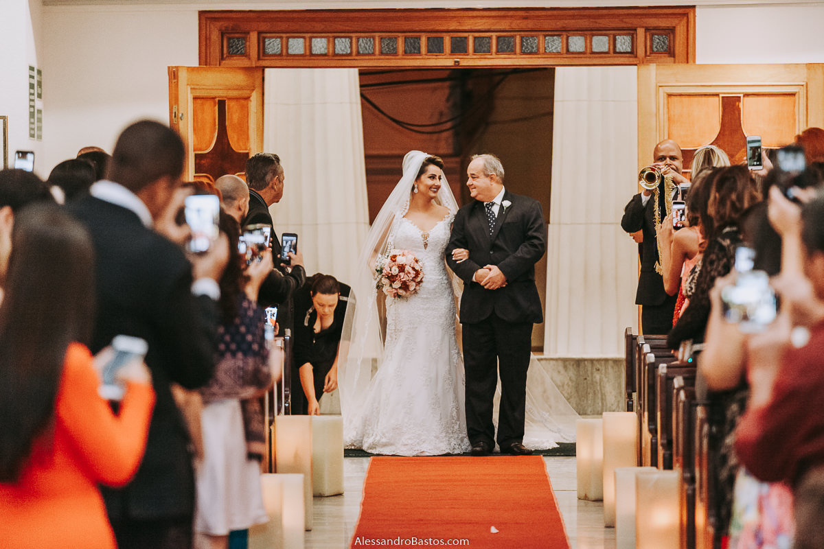 ao entrar na igreja a noiva e o seu pai trocam olhares fotografo casamento bh pre-wedding pre-casamento pos-casamento fotografia belo horizonte igreja santo cura d'ars todos com celulares para registrar
