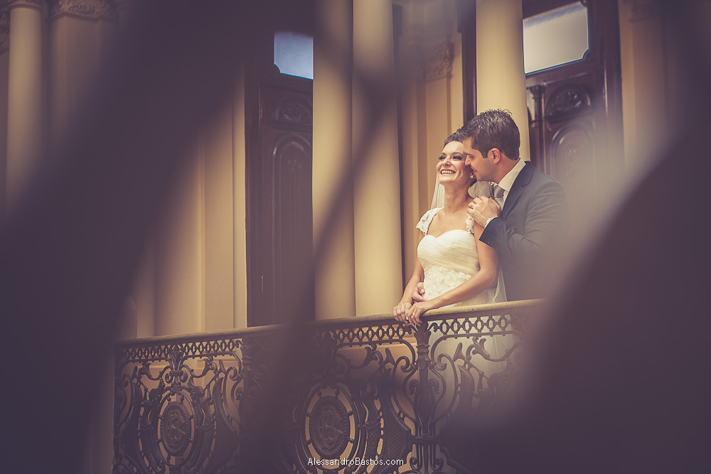 abraço gostoso do noivo nas fotos do casamento em bh no buffet catharina dos noivos na fotografia em belo horizonte para o fotografo bh no museu de artes e ofícios e um desfoque da grade do prédio