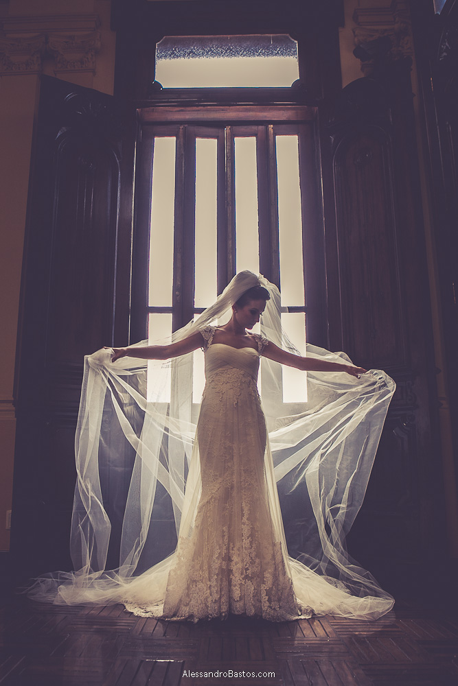 véu voando nas fotos do casamento em bh no buffet catharina dos noivos na fotografia em belo horizonte para o fotografo bh no museu de artes e ofícios e a noiva olhando pra baixo num contra-luz