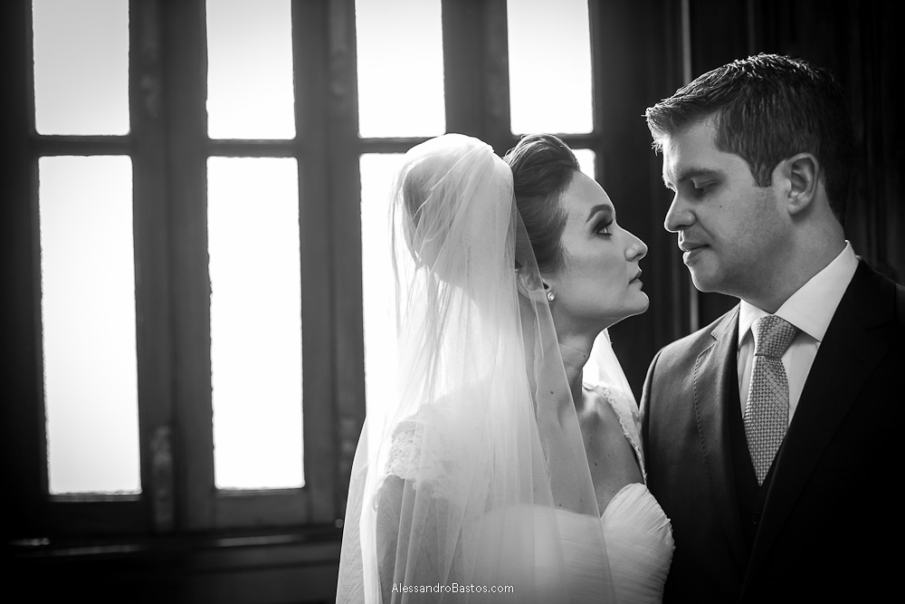 janela serve de cenário nas fotos do casamento em bh no buffet catharina dos noivos na fotografia em belo horizonte para o fotografo bh no museu de artes e ofícios e eles trocando olhares de forma séria