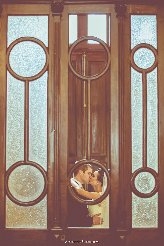 buraco na porta esconde os noivos nas fotos do casamento em bh no buffet catharina na fotografia em belo horizonte para o fotografo bh no museu de artes e ofícios e eles se beijam