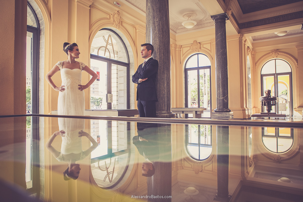 reflexo mostra o casal nas fotos do casamento em bh no buffet catharina dos noivos na fotografia em belo horizonte para o fotografo bh no museu de artes e ofícios e ela com mão na cintura