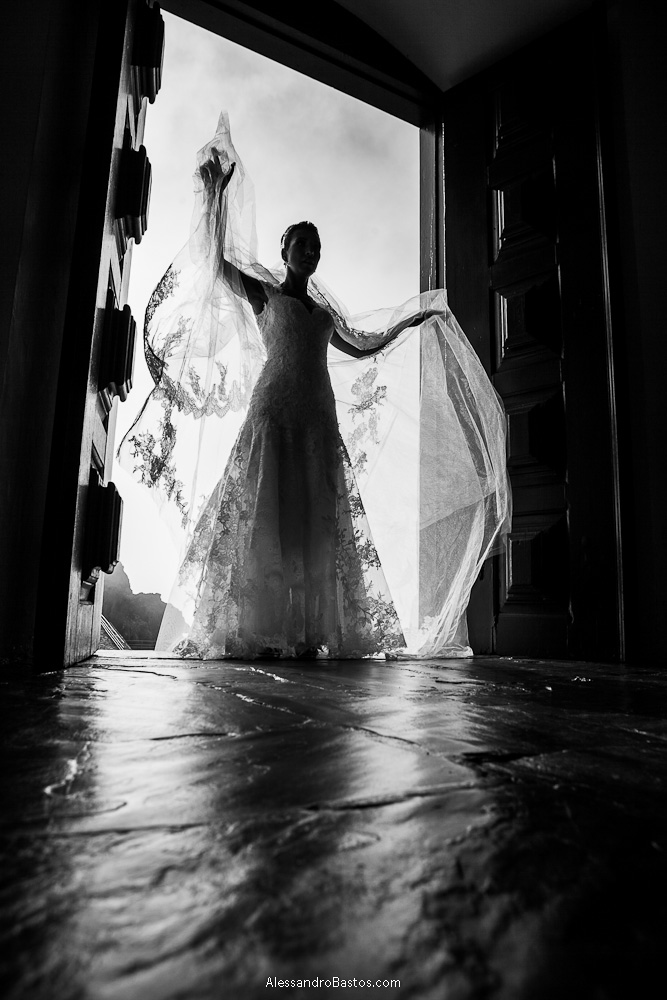 abrindo os braços está a noiva nas fotografias após o casamento em bh na serra da piedade bem na porta da igreja