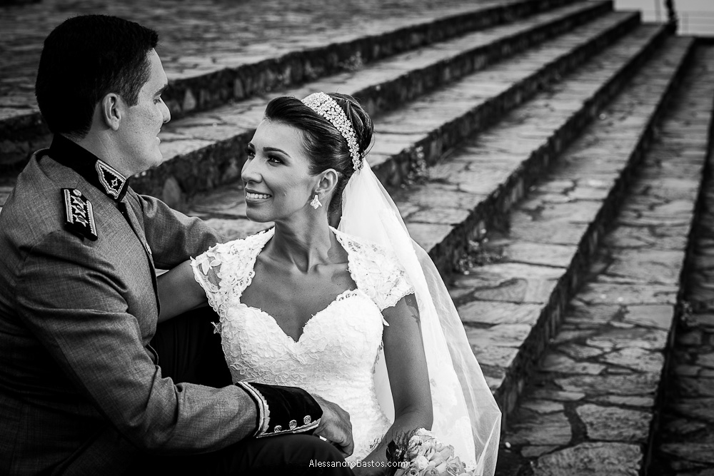os noivos trocam olharem nas fotografias após o casamento em bh na serra da piedade e sentados na escadaria em frente a igreja e o seu pátio