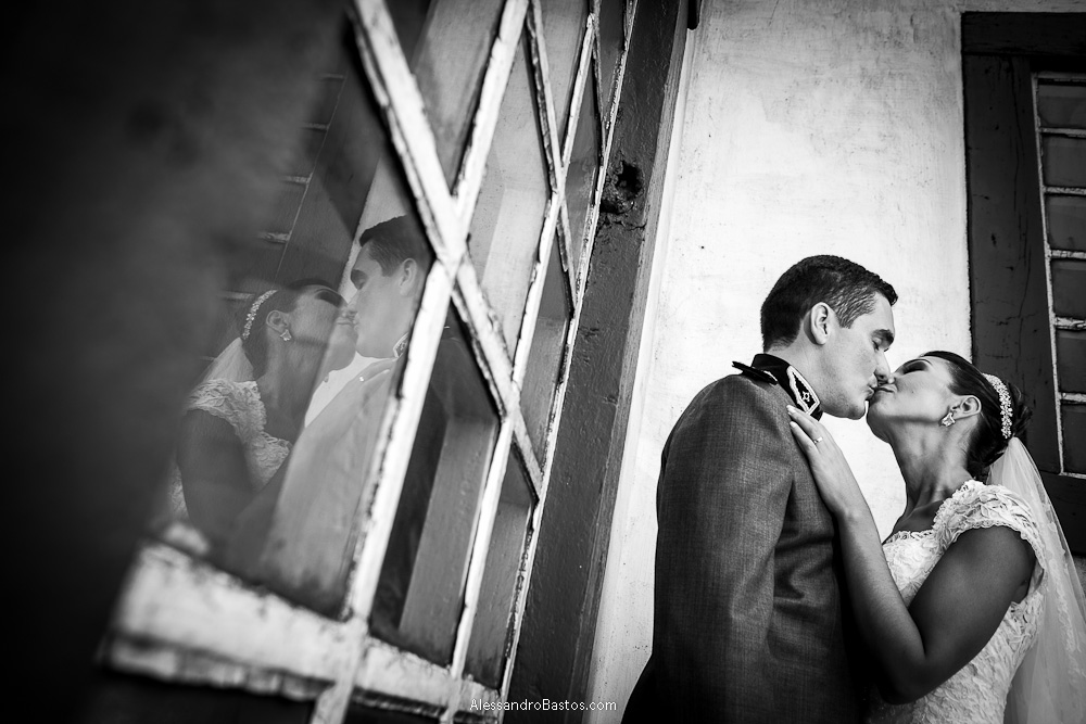 reflexo do beijo dos noivos nas fotografias após o casamento em bh na serra da piedade bem diante de uma janela